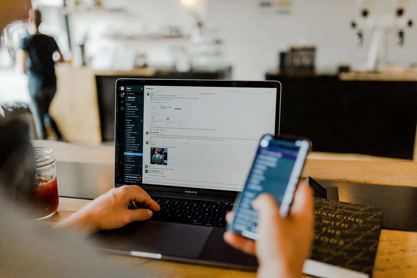 Person using a mobile banking app alongside a laptop
